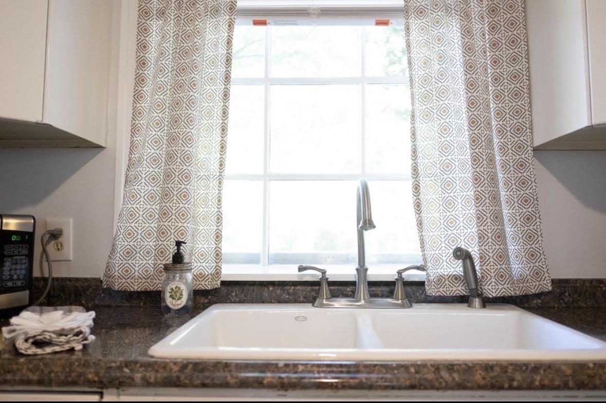 699 Shotwell Street Memphis, TN 38111 - Photo 14 of 33 Kitchen view of white cabinets, stainless steel microwave, and dark stone countertops