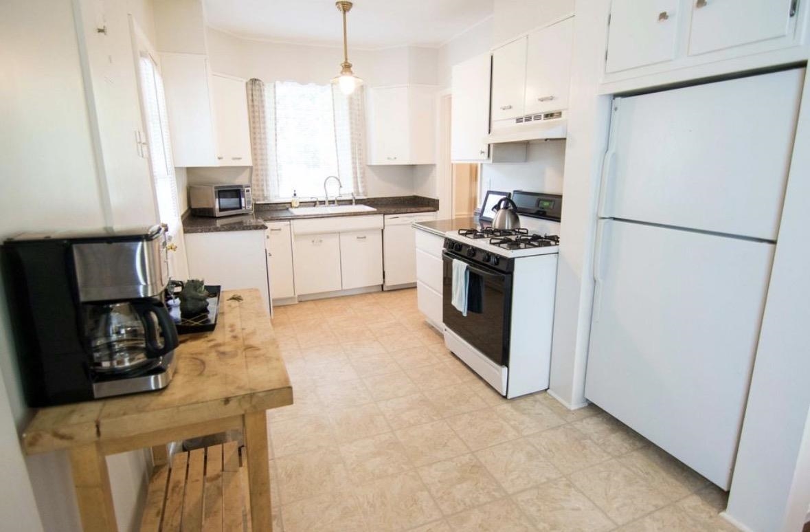 699 Shotwell Street Memphis, TN 38111 - Photo 15 of 33 Kitchen with white appliances, dark countertops, white cabinetry, decorative light fixtures, and light floors