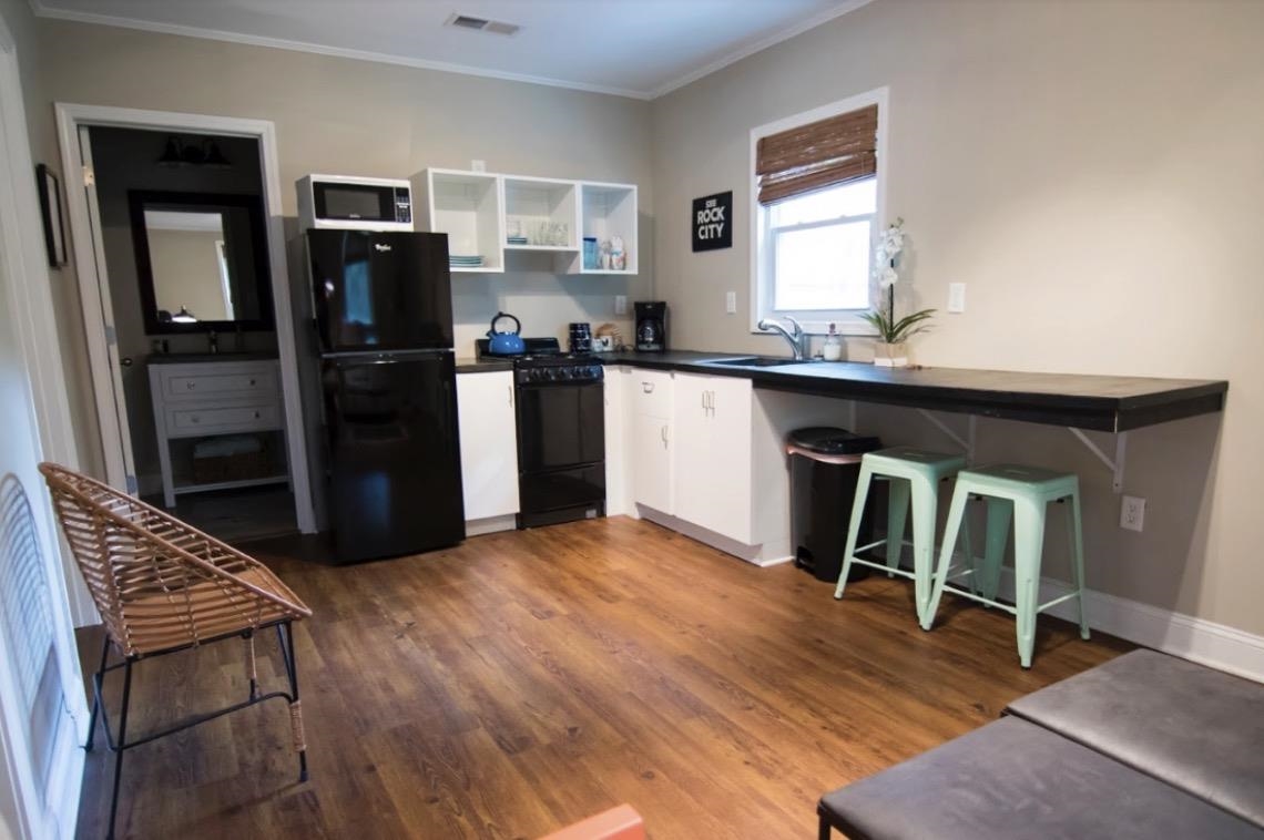 699 Shotwell Street Memphis, TN 38111 - Photo 27 of 33 Kitchen with black appliances, dark countertops, dark wood-type flooring, white cabinets, and crown molding
