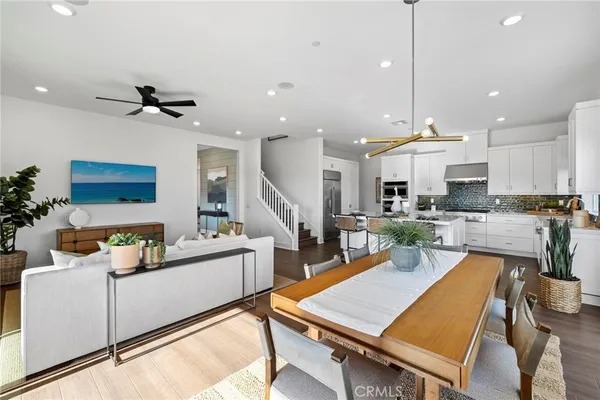 a view of kitchen with stainless steel appliances granite countertop a stove a sink a dining table and chairs