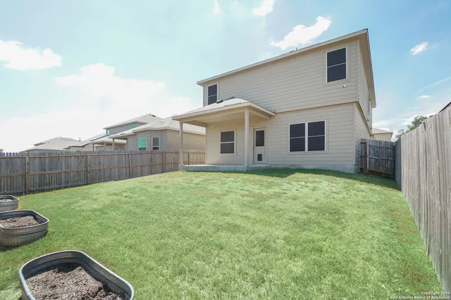 a view of a backyard with a barbeque and wooden fence