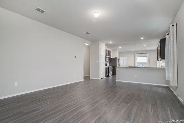 a view of an empty room with wooden floor