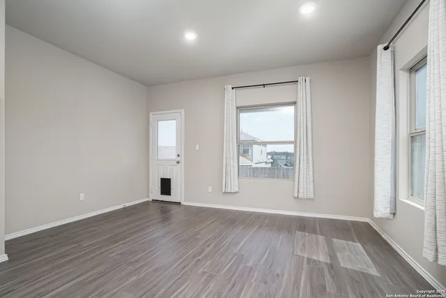 wooden floor in an empty room with a window