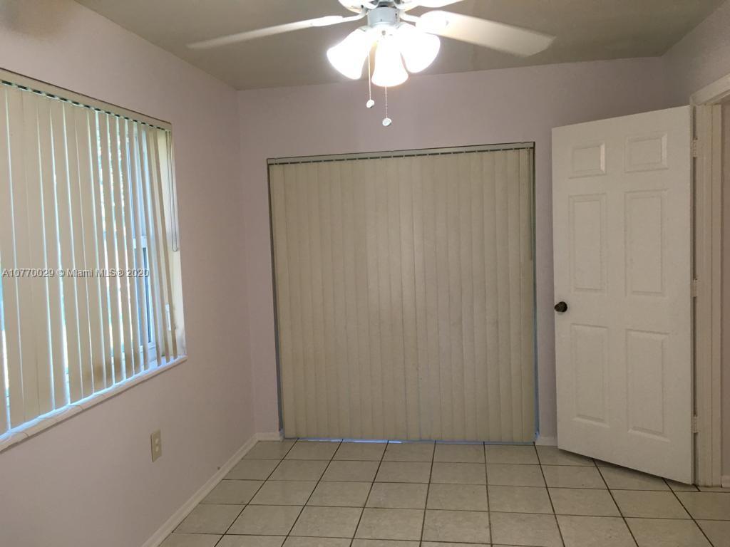 6301 Raleigh Street Hollywood, FL 33024 - Photo 15 of 19 an empty room with chandelier fan and windows