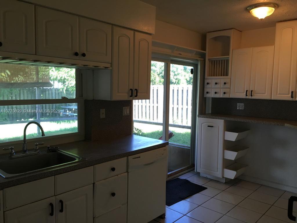 6301 Raleigh Street Hollywood, FL 33024 - Photo 16 of 19 a kitchen with granite countertop a sink a stove and cabinets