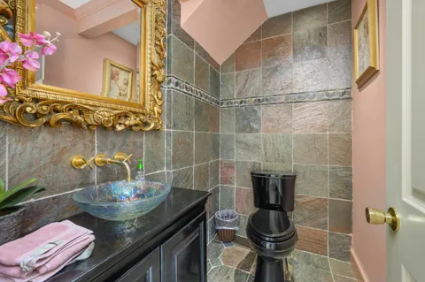 a bathroom with a granite countertop sink a toilet and a mirror