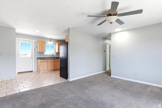 1613 Sunset Road Lake Point, UT 84074 - Photo 7 of 33 Open concept living space featuring a carpeted area and a kitchen with tile flooring