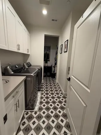a room with a black white checkered floor and a refrigerator
