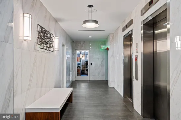 a view of a hallway with a dining table and chairs