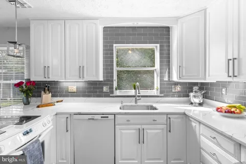 a kitchen with a sink cabinets and white appliances