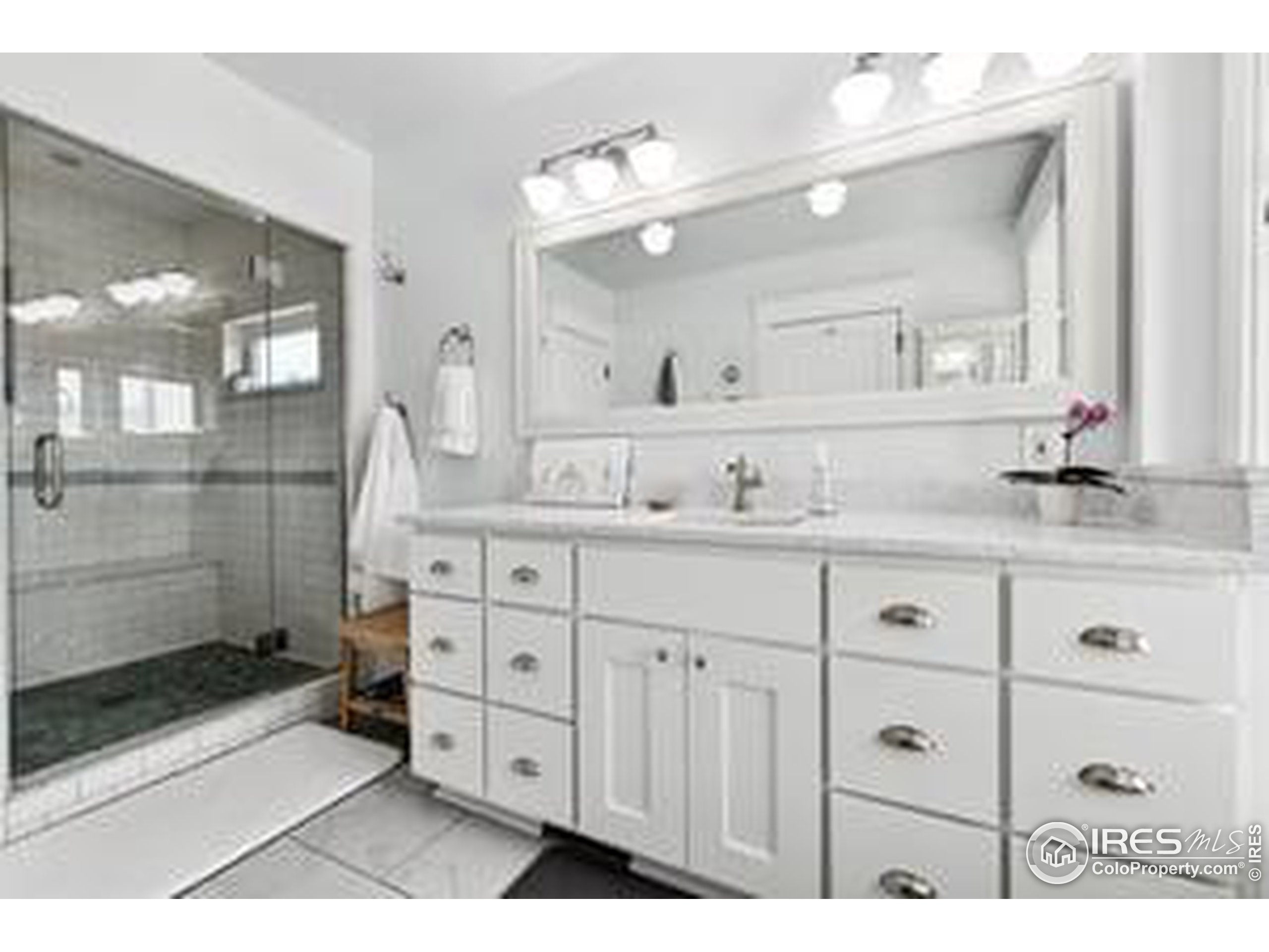 6261 County Road 41 Fort Lupton, CO 80621 - Photo 22 of 40 a bathroom with a sink a mirror and a shower