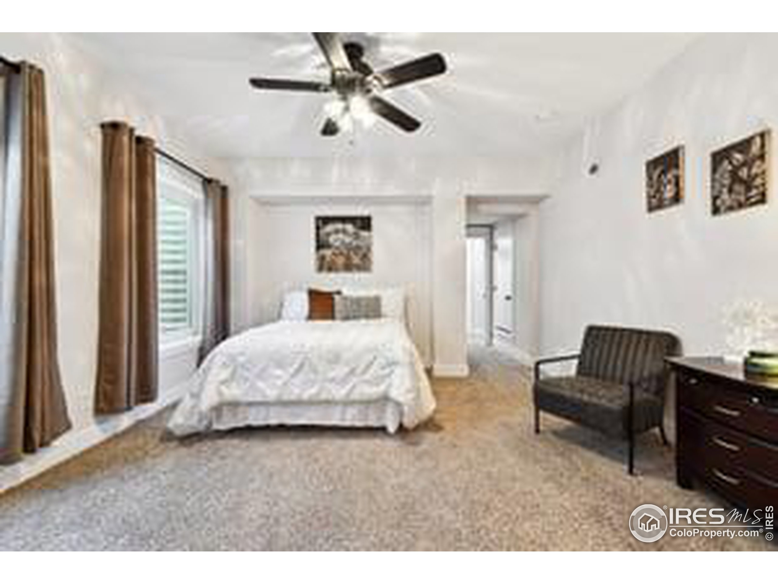 6261 County Road 41 Fort Lupton, CO 80621 - Photo 32 of 40 a spacious bedroom with a bed a couch and a chandelier