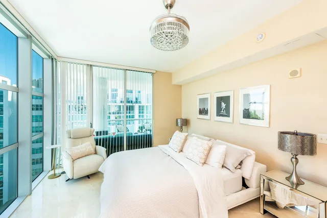 a bedroom with a bed and a large window