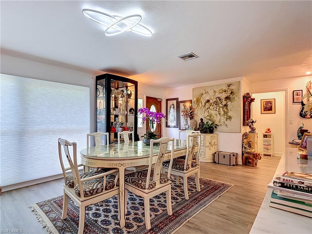 2280 Capri Court Naples, FL 34105 - Photo 7 of 49 a view of a dining room with furniture and wooden floor