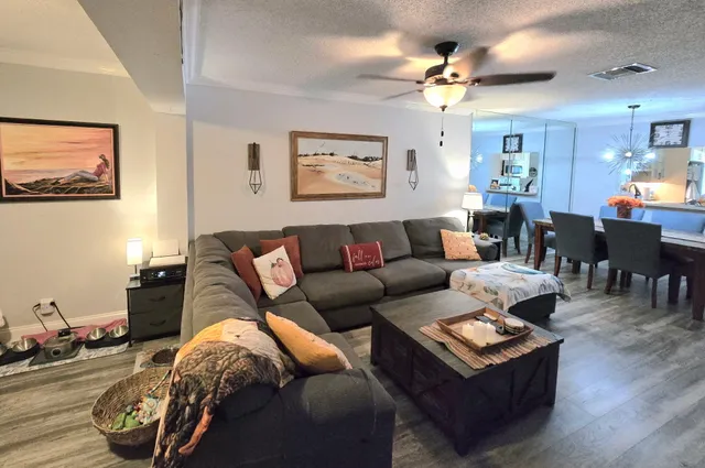 a living room with furniture a chandelier and a wooden floor