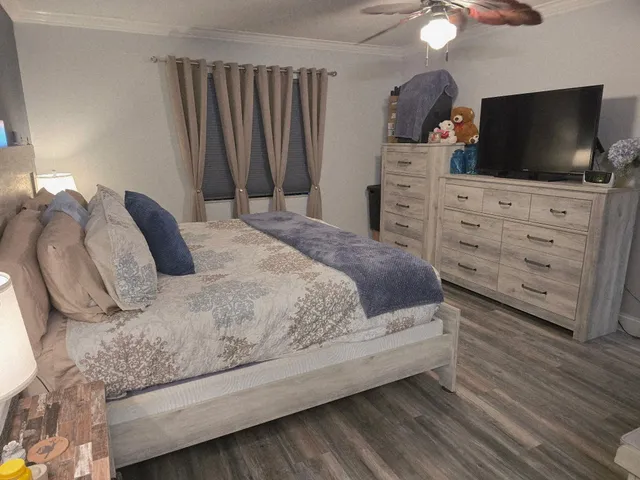 a bedroom with a bed and wooden floor