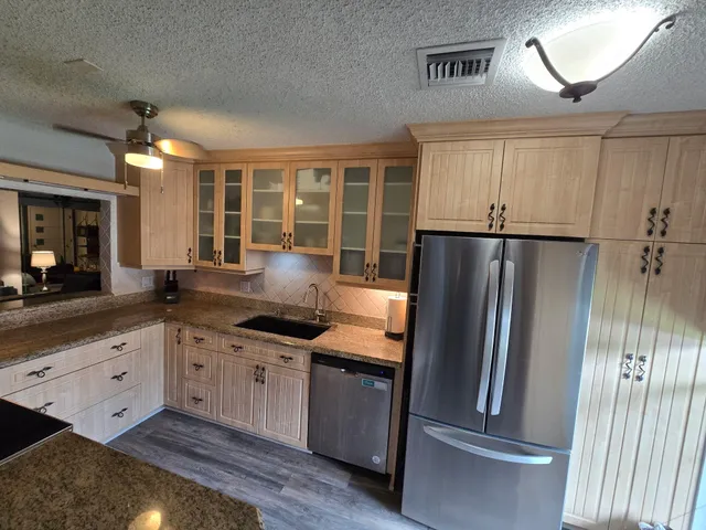 a kitchen with granite countertop a refrigerator and a sink