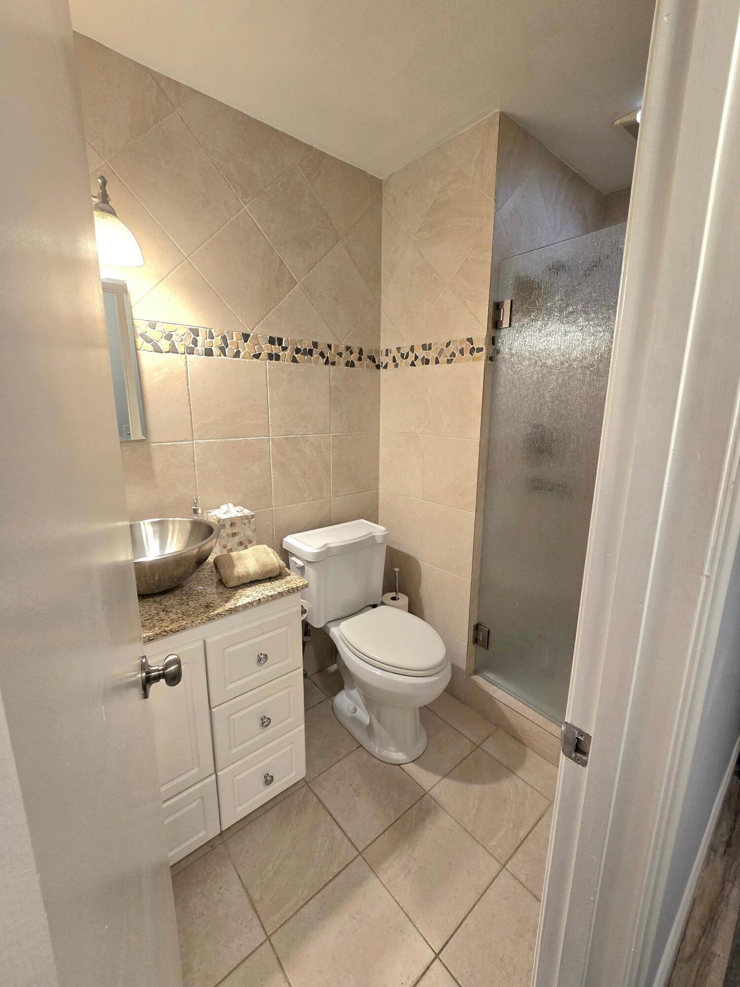 2720 Southwest 15th Street, Unit 2C Delray Beach, FL 33445 - Photo 22 of 31 a bathroom with a granite countertop sink toilet and shower