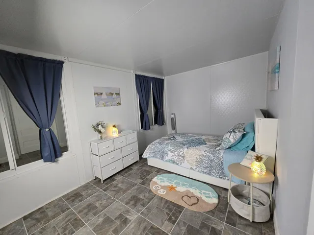 a bedroom with a bed and a large window