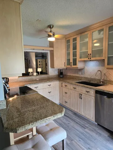 a kitchen with kitchen island granite countertop wooden cabinets and a granite counter tops
