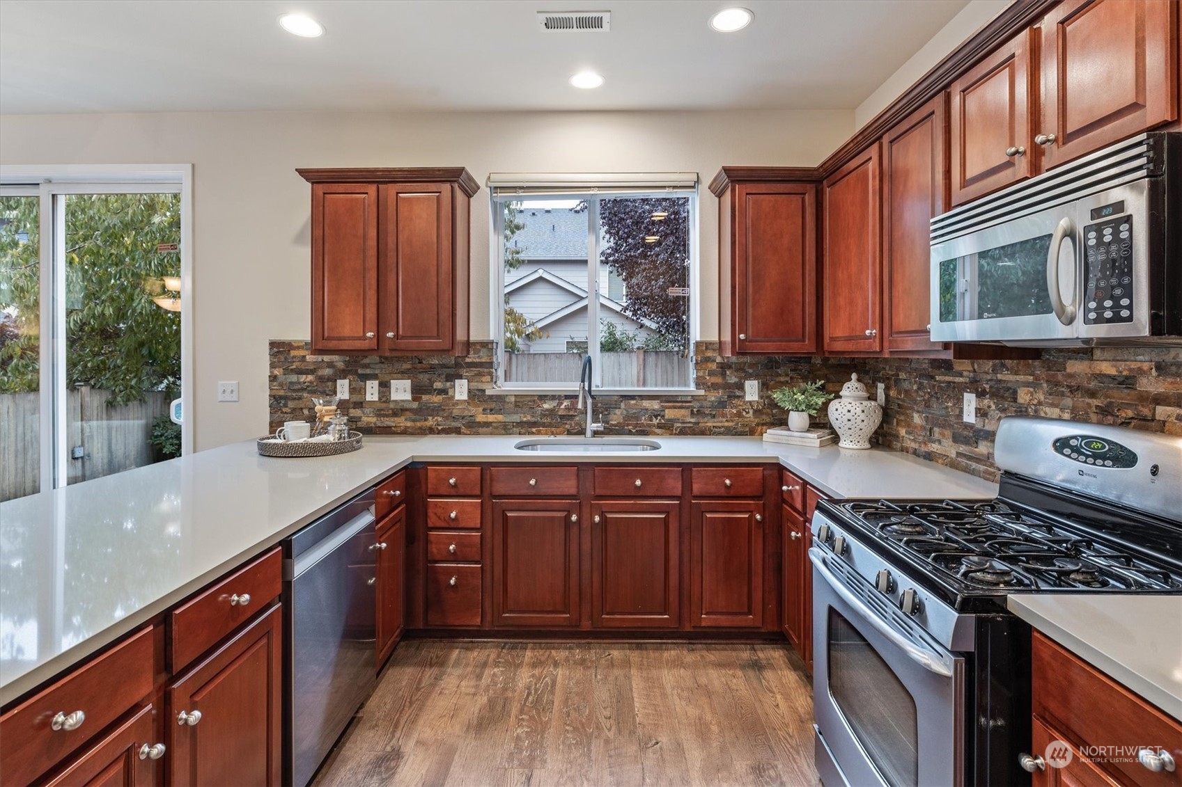16023 35th Park Southeast Bothell, WA 98012 - Photo 8 of 34 a kitchen with stainless steel appliances granite countertop a stove a sink dishwasher and cabinets with wooden floor