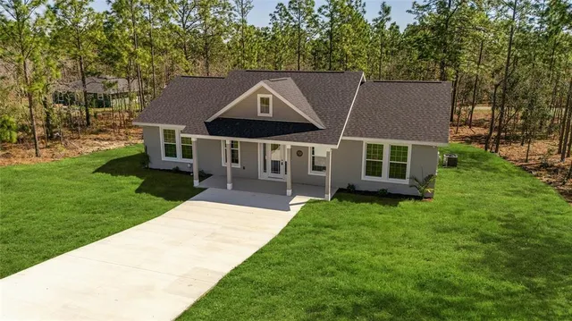a aerial view of a house next to a big yard and large trees