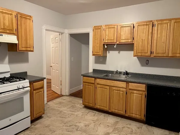 a kitchen with granite countertop a stove sink and cabinets