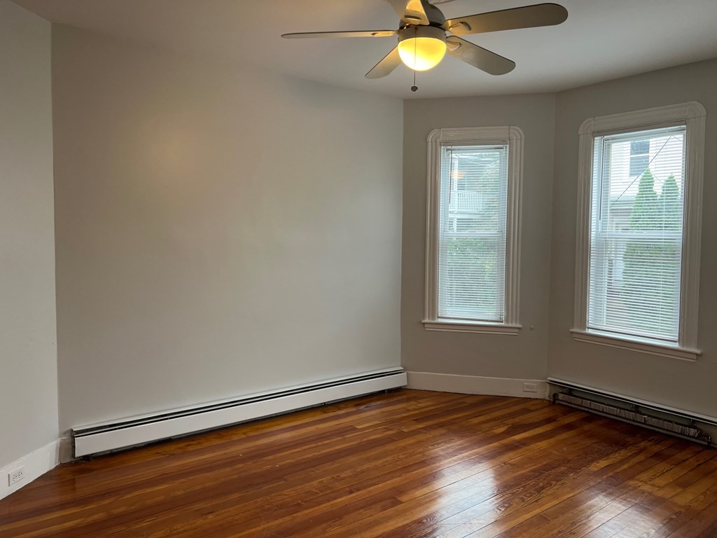 3 Carson Street, Unit 1 Boston, MA 02125 - Photo 11 of 14 an empty room with wooden floor and windows