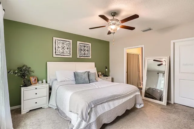 a bedroom with a bed and a flat screen tv in white walls