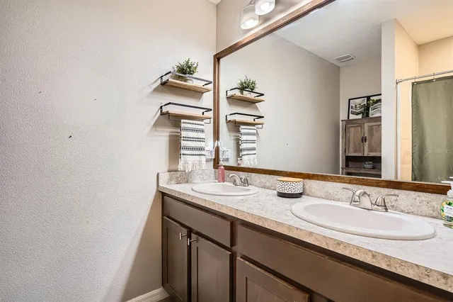a en suite bathroom with a sink double vanity and tub