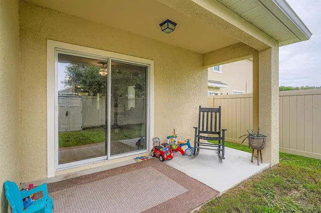 a view of a backyard with large tree and wooden fence