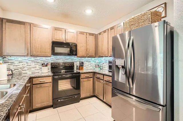 a kitchen with stainless steel appliances granite countertop a refrigerator sink and stove