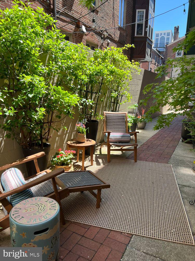 908 Spruce Street, Unit 10 Philadelphia, PA 19107 - Photo 30 of 41 a backyard of a house with table and chairs
