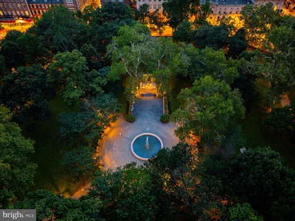 an aerial view of a house with outdoor space and trees all around