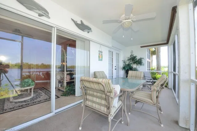a dining room with furniture and large windows