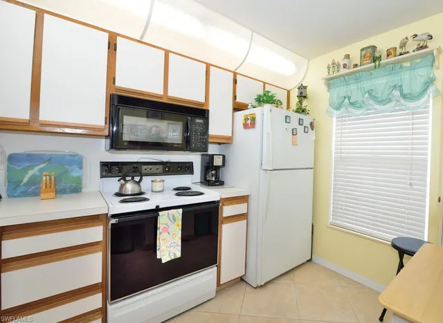 a kitchen with stainless steel appliances granite countertop a refrigerator a stove and a sink