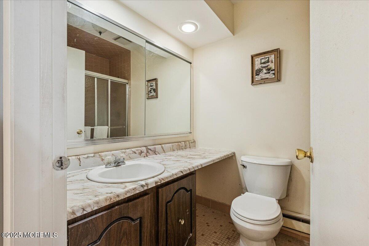 93 Arrowood Road, Unit G Manalapan, NJ 07726 - Photo 13 of 16 a bathroom with a granite countertop sink toilet and a mirror