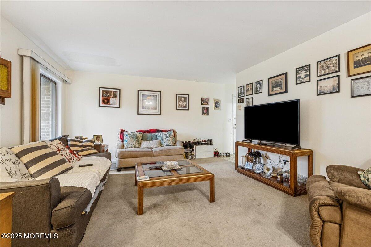93 Arrowood Road, Unit G Manalapan, NJ 07726 - Photo 9 of 16 a living room with furniture and a flat screen tv