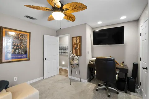 a view of a workspace with furniture and a flat screen tv