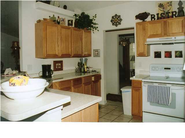 185 Beacon Way Miramar Beach, FL 32550 - Photo 5 of 14 a kitchen with a sink and a stove top oven with wooden floor