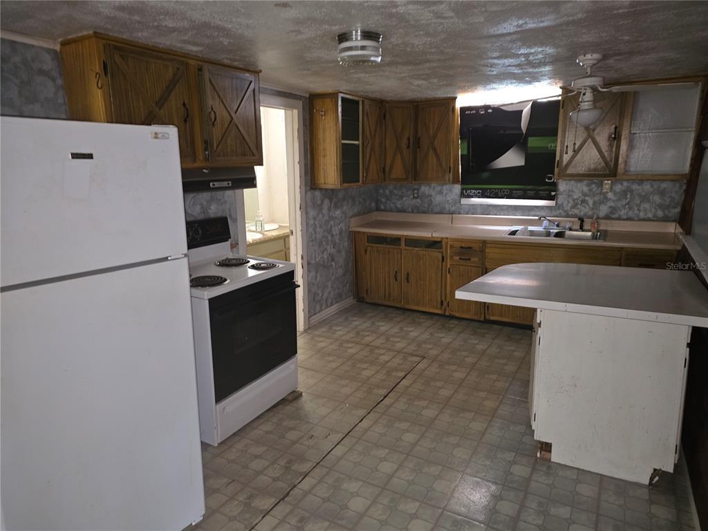404 Northwest 7th Street Mulberry, FL 33860 - Photo 14 of 22 a kitchen with a refrigerator and a sink