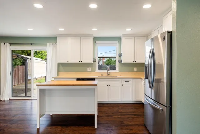 a kitchen with stainless steel appliances granite countertop a refrigerator and a sink
