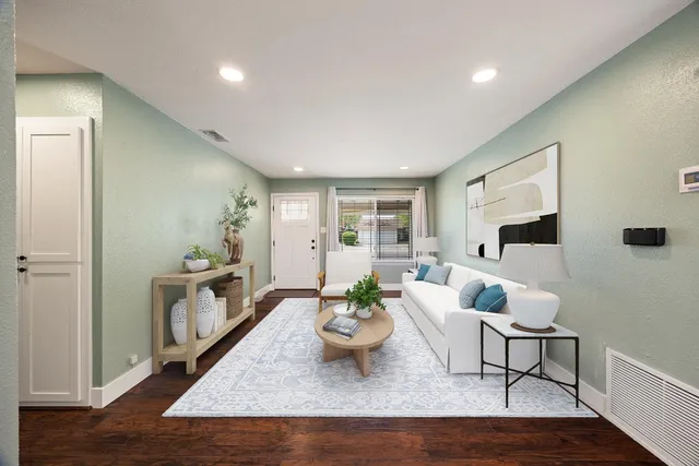 a living room with furniture and a wooden floor