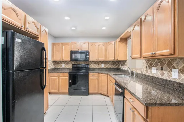 a kitchen with granite countertop a sink stove and cabinets