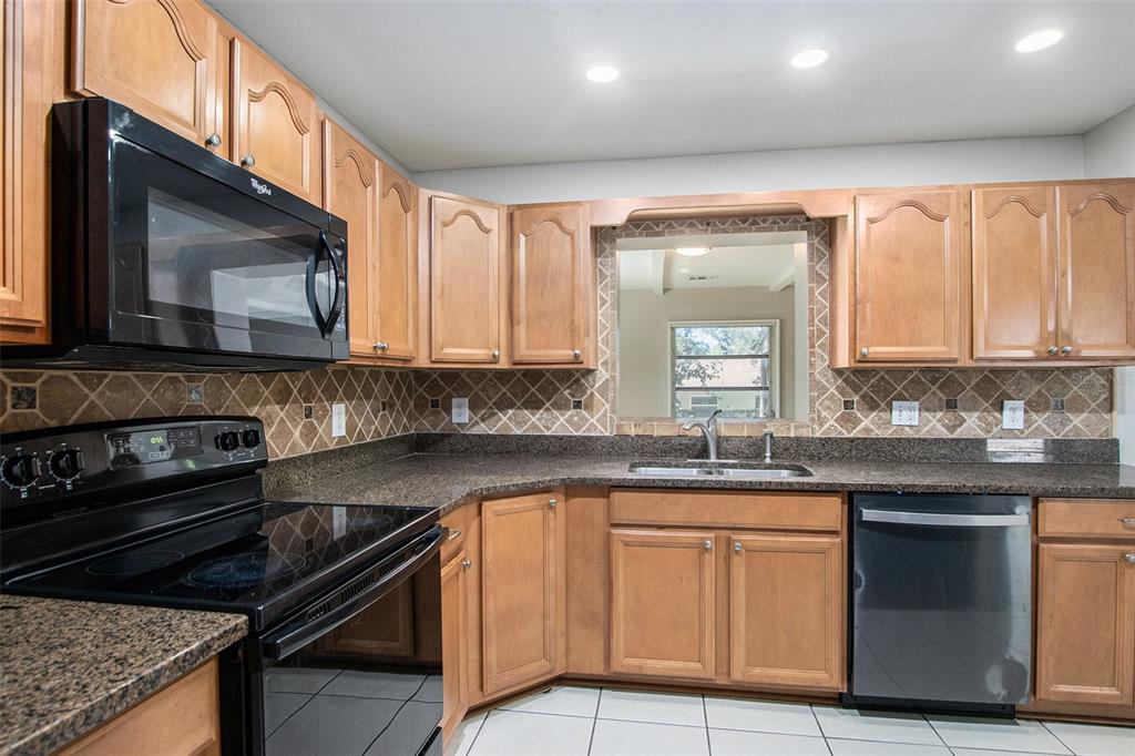 217 Faithway Drive Seffner, FL 33584 - Photo 13 of 29 a kitchen with granite countertop a sink stove and cabinets
