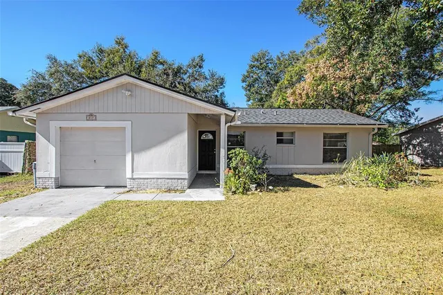a front view of house with yard and trees around