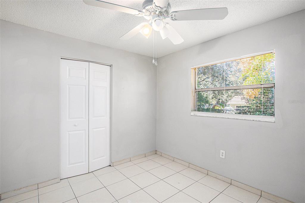 217 Faithway Drive Seffner, FL 33584 - Photo 21 of 29 an empty room with windows and chandelier fan