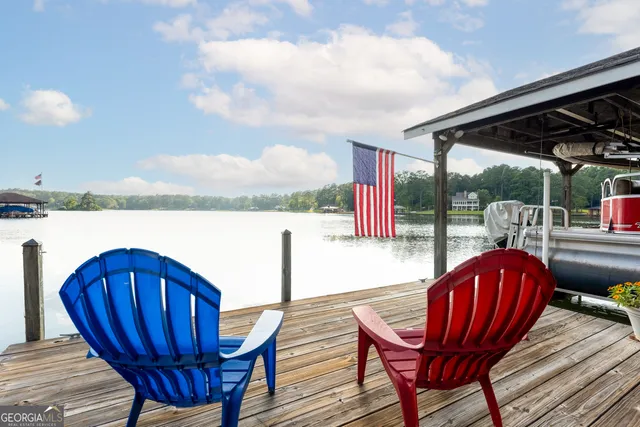a view of a chairs and table in the patio next to a yard