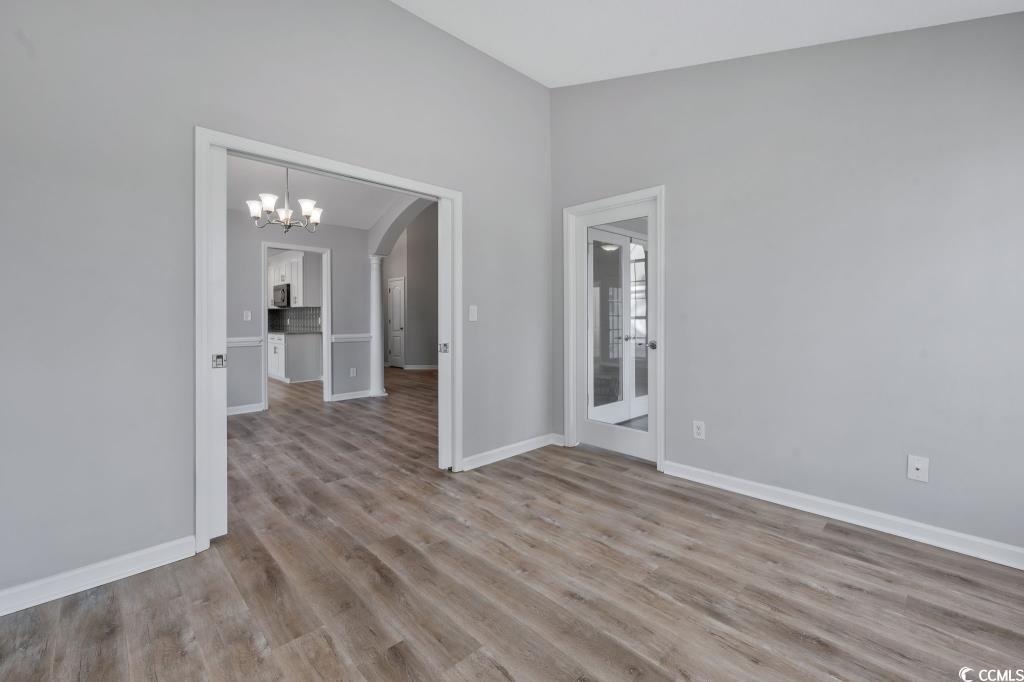1639 Coventry Road Surfside Beach, SC 29575 - Photo 26 of 38 Spare room with an inviting chandelier, lofted ceiling, and light hardwood / wood-style flooring