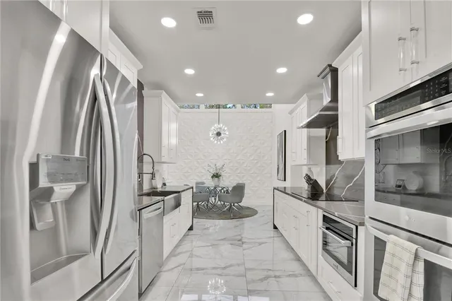 a kitchen with granite countertop white cabinets and stainless steel appliances